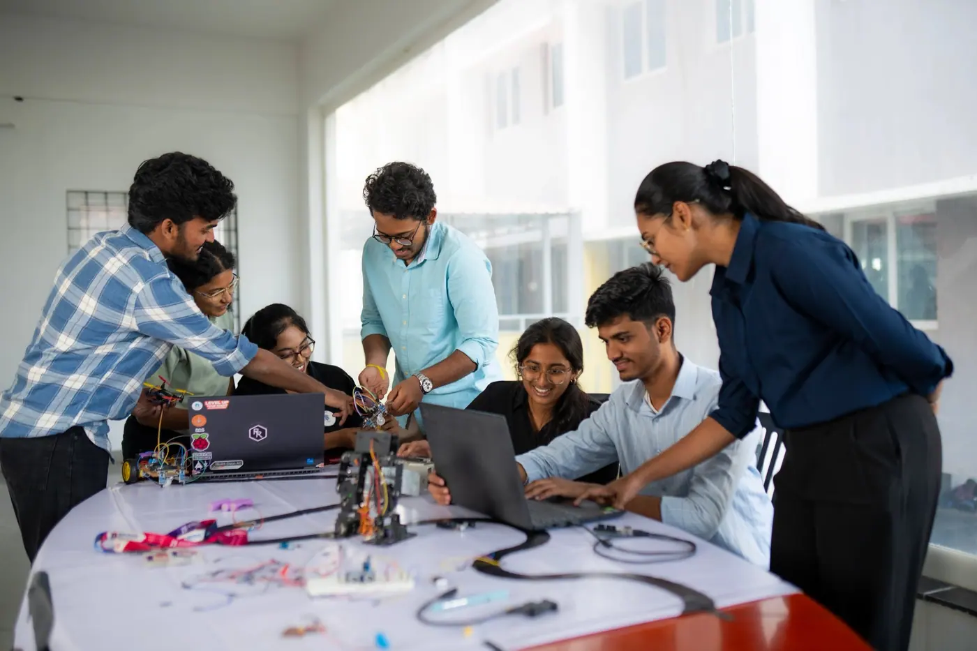 Students and a mentor building an electronics and robotics project together