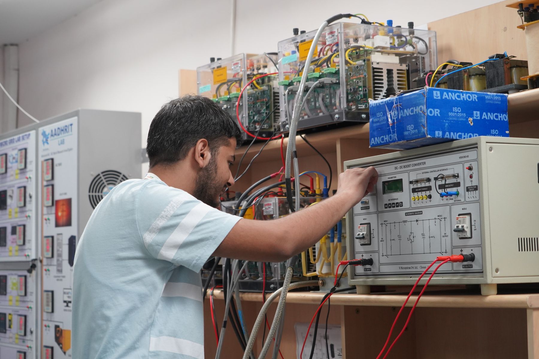 An engineering student wiring a test panel in an electrical laboratory