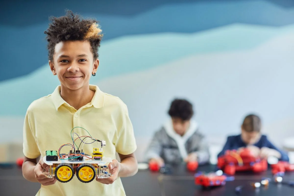 A student presenting a robot built during a classroom project